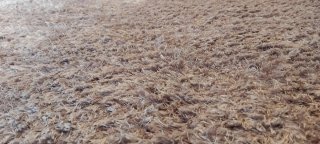 Alfombra púrpura/plateada de tela.