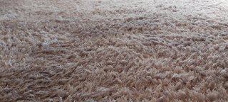 Alfombra púrpura/plateada de tela.