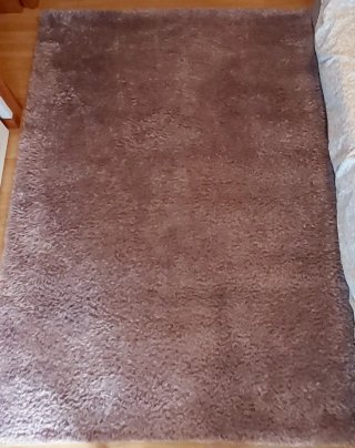 Alfombra púrpura/plateada de tela.