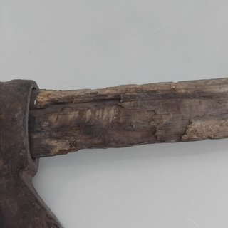 Hacha antigua de metal y madera