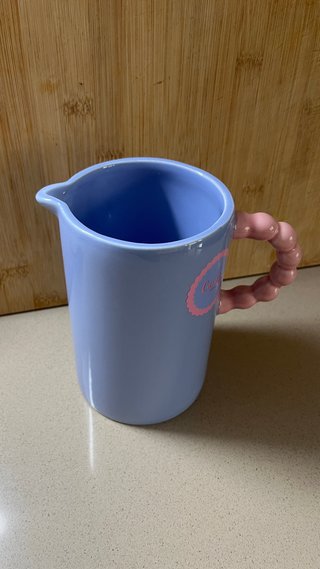 Jarra de cerámica azul con asa rosa