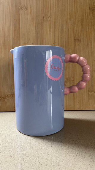 Jarra de cerámica azul con asa rosa