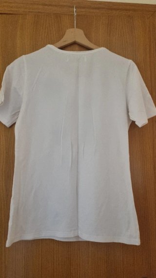 Camiseta blanca con pedrería que forman estrellas.