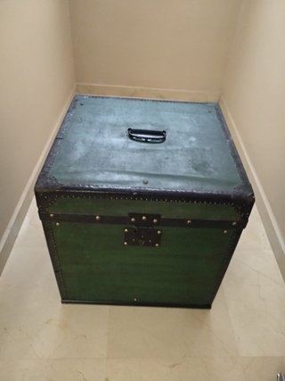 Baúl de madera verde, tapizado por dentro.