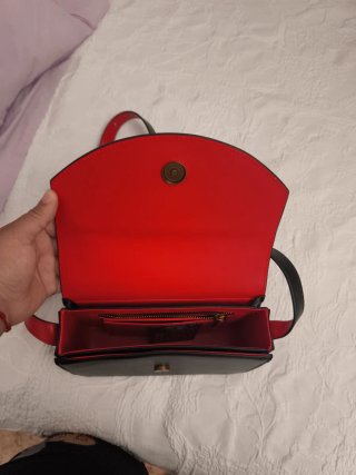 Bolso negro con logo dorado y correa