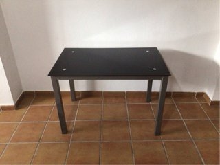 Mesa de cristal negro y metal gris.
