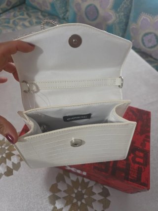 Bolso de mano blanco con lazo de pedrería