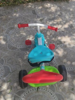Triciclo infantil azul, verde y rojo