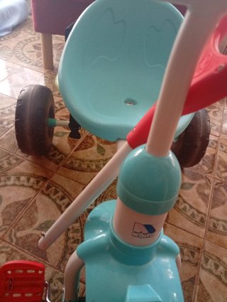 Triciclo infantil azul, verde y rojo