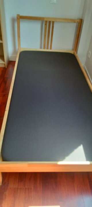 Cama individual madera con base tapizada.
