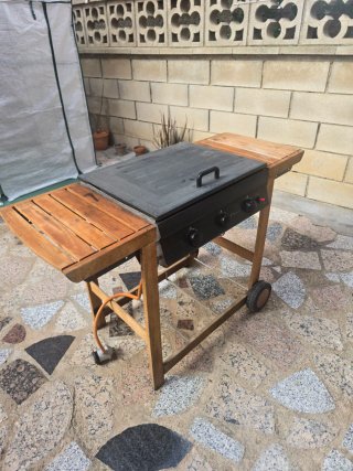 Barbacoa de gas negra y madera.