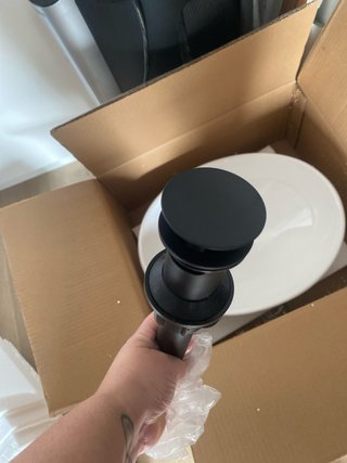 Lavabo de cerámica blanco y sifón negro