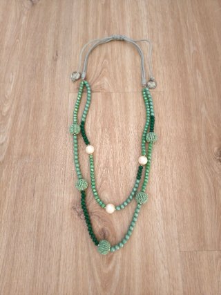 Collar largo verde con borlas.