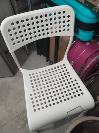 Silla blanca de plástico con diseño perforado