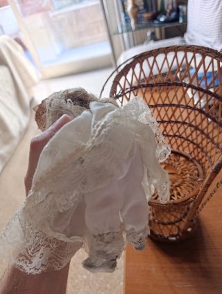Muñeca de porcelana con sillón de mimbre