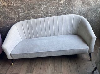 Sofá de tela beige con patas doradas