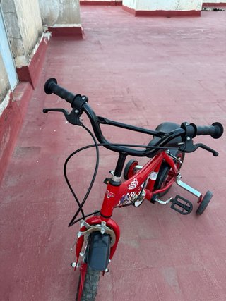 Bicicleta infantil roja con ruedines