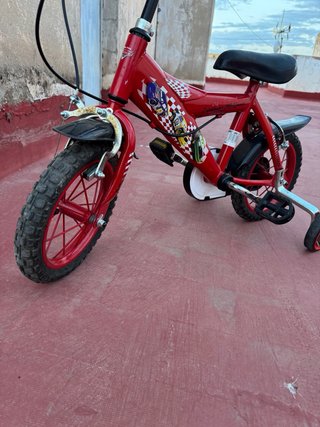 Bicicleta infantil roja con ruedines