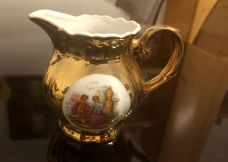 Taza y lechera de porcelana dorada