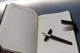Agenda y bolígrafo nuevos. Negro y dorado.