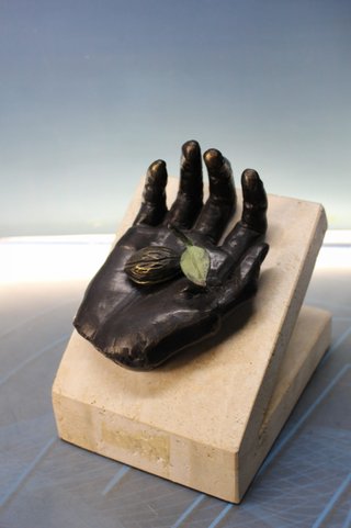 Escultura de Pocho. Mano con fruto.