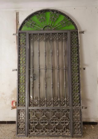 Puerta de forja acristalada