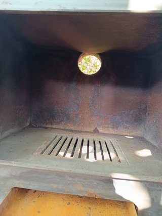 Estufa de leña metálica con puerta de cristal
