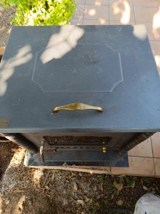 Estufa de leña metálica con puerta de cristal