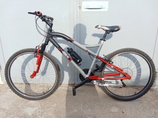 Bicicleta de montaña gris y roja lista para rodar