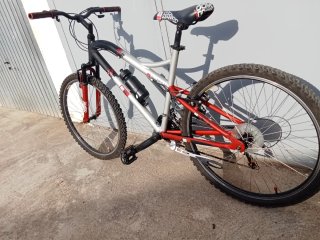 Bicicleta de montaña gris y roja lista para rodar