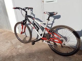 Bicicleta de montaña gris y roja lista para rodar