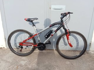 Bicicleta de montaña gris y roja lista para rodar