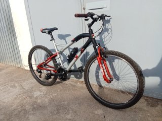 Bicicleta de montaña gris y roja lista para rodar