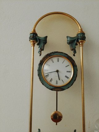 Reloj de pared con péndulo dorado