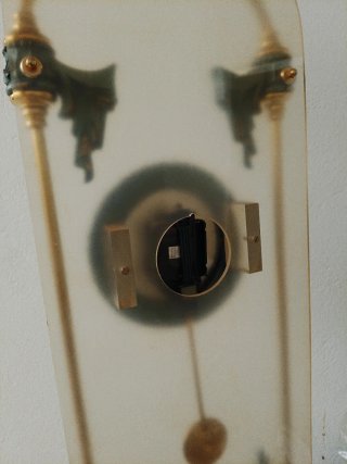 Reloj de pared con péndulo dorado