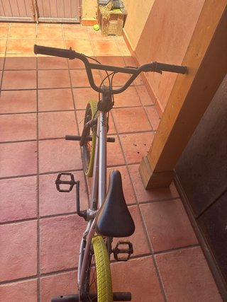 Bici BMX plateada con ruedas amarillas