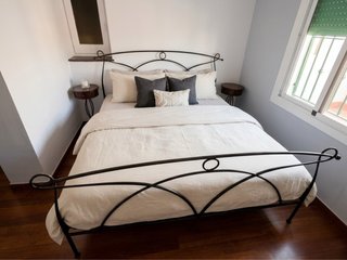 Cama de forja negra con mesitas