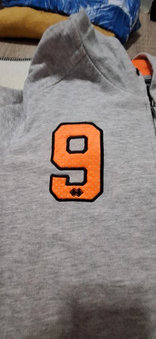 Sudadera gris con número naranja