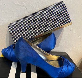 Zapatos de tacón azul y bolso plateado