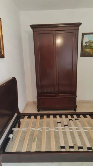 Cama y armario de madera oscura
