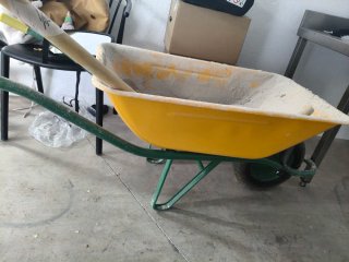 Carretilla de obra amarilla con un día de uso