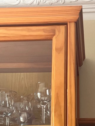 Mueble de madera color miel con vitrina y cristal