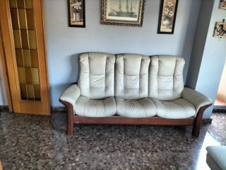 Sofá de piel beige con estructura de madera