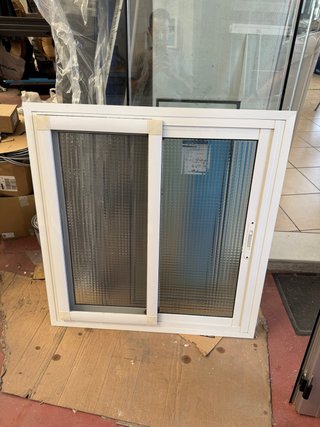 Ventana corredera blanca con vidrio texturizado