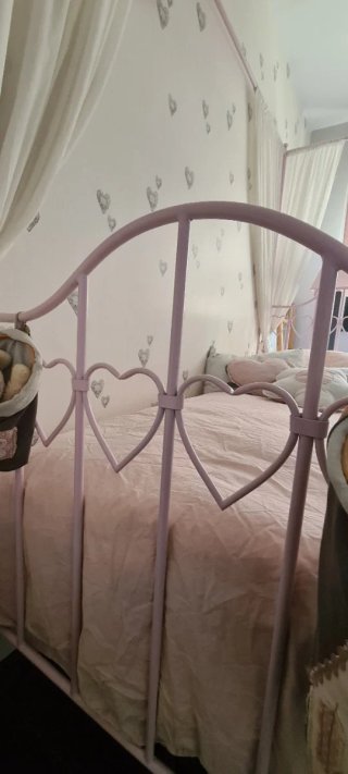 Cama juvenil rosa con dosel.