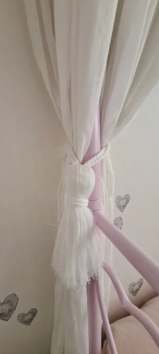 Cama juvenil rosa con dosel.