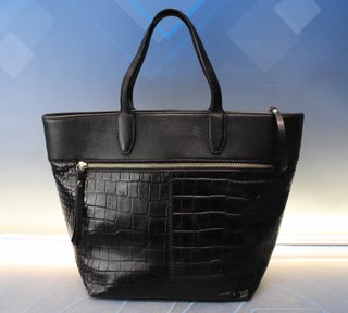 Bolso de polipiel negra tipo tote o trapezoidal, de mano.