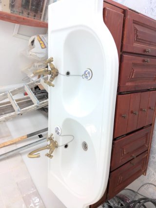Mueble de baño con lavabo doble y grifos.