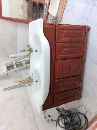 Mueble de baño con lavabo doble y grifos.