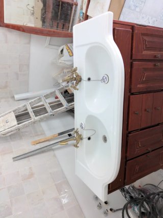 Mueble de baño con lavabo doble y grifos.